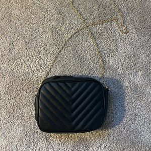 Black purse with thin gold chain